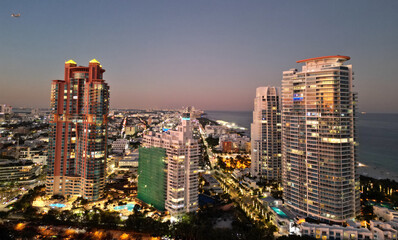 Obraz premium Miami South beach night light. Aerial skyscraper cityscape at night. Night city aerial view. Luxury skyscraper in Miami, Florida. City skyline in evening. Aerial cityscape. Illuminated architecture