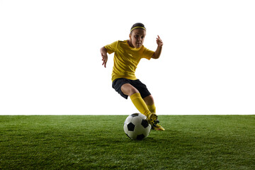 Obraz premium Focused girl, child in yellow jersey and black shorts, soccer player training against white studio background. Game on. Concept of sport, childhood, motion, competition, activity