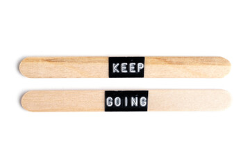 Keep going, text on wooden stick isolated on white background.