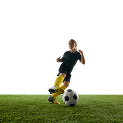 Dynamic image of motivated child, girl in sportswear in motion on field, training, playing soccer against white studio background. Concept of sport, childhood, game, competition, activity