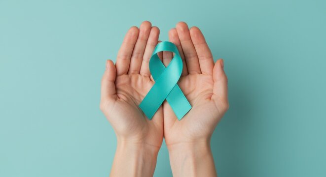 Sexual Assault Awareness Month concept. Hands of woman holding teal ribbon on blue background.  Symbol for Ovarian and Cervical cancer. Gynecological cancer, PCOS. Women's Health. Banner, copy space. 