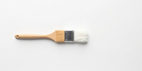 A simple wooden-handled paintbrush with white bristles rests on a clean white background, ideal for DIY projects and artistic endeavors.