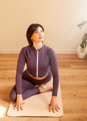 Portrait of a middle-aged woman doing yoga in the living room