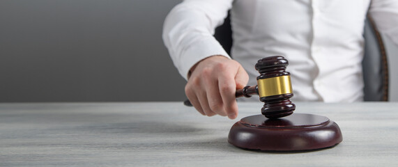 Male judge in a courtroom striking the gavel.