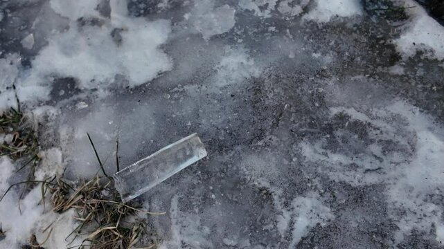 hard ice on the ground. Ice sculptures on the river bank in San Vigilio di Marebbe. Ice is opaque is all tha shades of white and blue. Trees standing neaby are covered with frost.