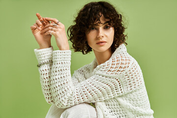 A young and beautiful woman with curly hair sits gracefully, exuding charm and confidence.