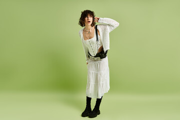 A young woman poses in a stylish outfit against a vibrant green background.