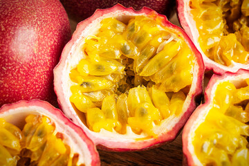 Close-up background of sliced or cut ripe juicy vegetarian passion fruit with sweet edible yellow...