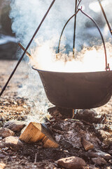 Outdoor Cooking Over Open Fire with Hanging Pot and Smoky Rustic Atmosphere