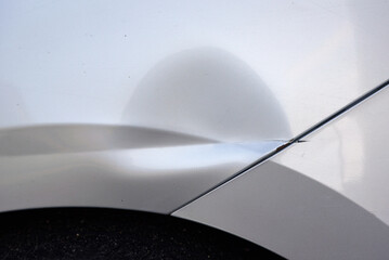 Scratched and dented car exterior from side impact, damage to the rear arch and paint caused by...