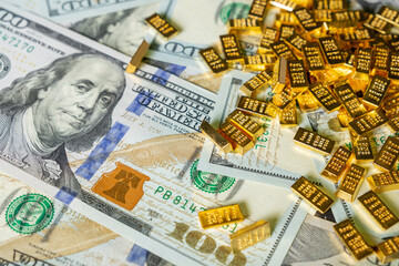 gold mini bars scattered on us dollar bills, symbolizing wealth, financial stability, investment...