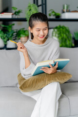 young woman writing diary planning on notebook at home