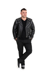 Fototapeta premium A handsome dark-haired man in a black leather jacket, black T-shirt, trousers and sneakers on a white background