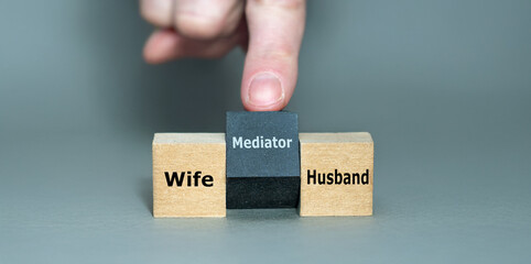 Cubes with the words 'wife, husband and mediator'. Symbol for solving a conflict with a mediator.