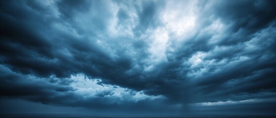 Obraz premium Majestic storm clouds gather over the horizon, creating a dramatic and powerful atmosphere with their swirling, deep gray formations.