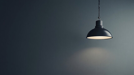 Illuminating Space: A sleek, modern pendant light casts a warm glow against a gray wall, blending simplicity with functionality for an inviting ambiance.