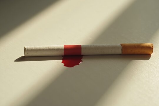 A Cigarette and a Drop of Blood on a White Surface - Generative AI