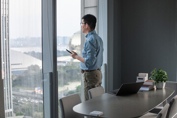 asian man using smart phone in modern office
