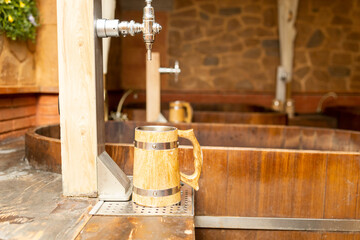 Photograph of a faucet and pitcher in a spa with bathtubs full of beer.