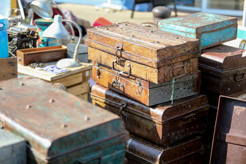 Lively flea market scene in France with vintage items, antiques, books, and decorations. People...