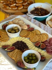 Table With Appetizers including Charcuterie Platter with Cheese, Crackers, Olives, Fresh Figs, Chocolate Covered Almonds, and Salami