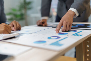 Professional team analyzing financial charts, discussing performance metrics and collaborative...