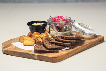 a wooden serving board with a variety of appetizer-style items arranged on it. 