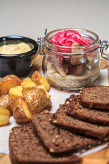a wooden serving board with a variety of appetizer-style items arranged on it. 
