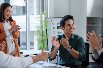 Diverse business colleagues applauding enthusiastically, sharing workplace camaraderie, supporting team success with energetic hand clapping