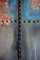 Una croce formata dai bulloni di saldatura su una vecchia cisterna arrugginita