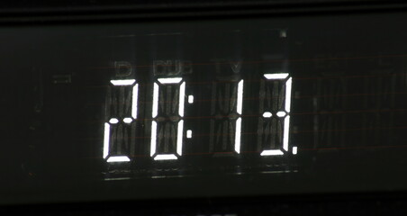 Close up of illuminated digital clock showing 20,11, evoking concepts of time, technology, and schedule