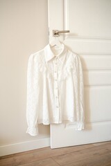 An Elegant White Blouse Beautifully Hanging on a Door for Display and Fashion Inspiration