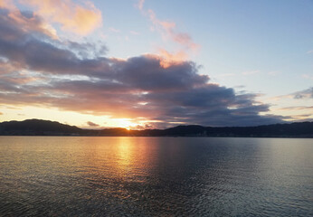 美しく広い湖に夕日が沈んでいく時の風景