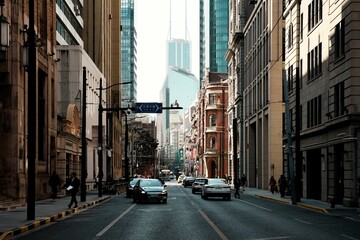 Street scene in Shanghai with modern skyscrapers and classic architecture under a clear sky