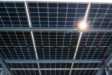 Bilateral solar panels, photovoltaics with sun reflection - alternative source of electricity, concept of sustainable and renewable resources. Panoramic view.