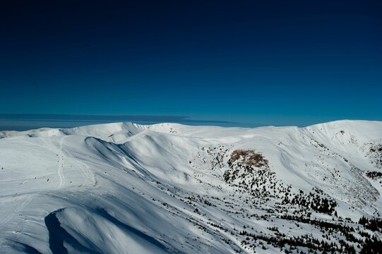 Breathtaking winter landscape of snow-covered mountains under a clear blue sky