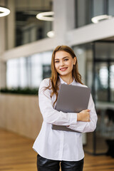 Portrait of businesswoman stand and holding laptop in office