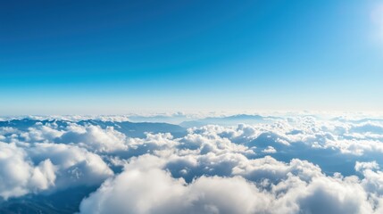 Fototapeta premium Bright Blue Sky with Soft White Clouds Over Mountain Landscape