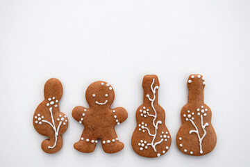 Romantic decorated gingerbread cookies in a shape of guitar, treble clef and man, white background,...