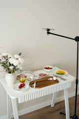 food blogger recording video on a tripod at home kitchen with phone. showing preparing some recipe.