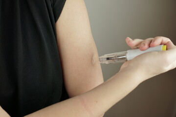 Woman Self Injecting in Forearm with Injection Pen for Diabetes Rheumatoid Arthritis and Autoimmune...
