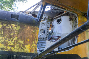 Disassembled cockpit of an old yellow abandoned wrecked airplane