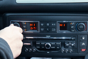 Obraz premium Adjusting the climate control settings on a car dashboard, focusing on comfort and modern vehicle features. 
