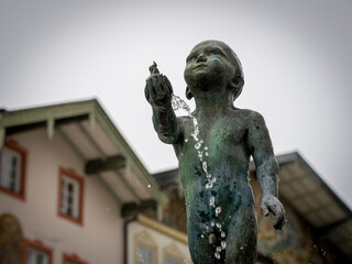 Bronzeskulptur eines kleinen Jungen als Brunnen in der Altstadt von Bad Tölz