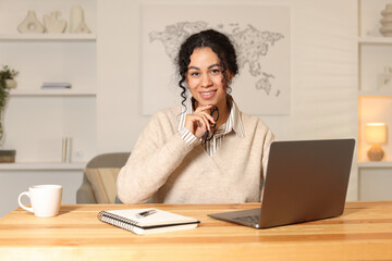 Beautiful woman working on laptop at desk in home office