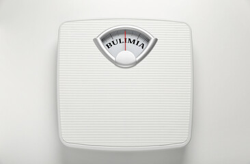 Mechanical scales with word Bulimia instead of numbers on white background, top view