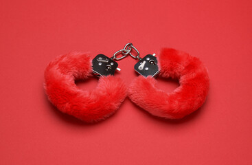 Red sexy fluffy handcuffs on a red