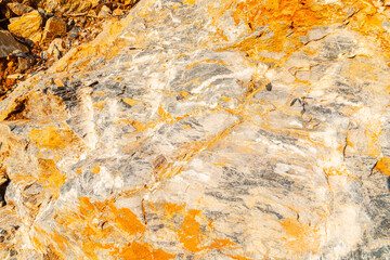 The background is a beautiful rough stone texture in close-up with bright colors of mineral inclusions