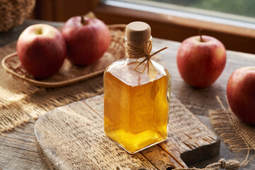 Apple cider vinegar in a glass bottle on a table