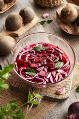 Preparation of fermented beet kvass in a bowl from fresh beetroot, onions, garlic and spices